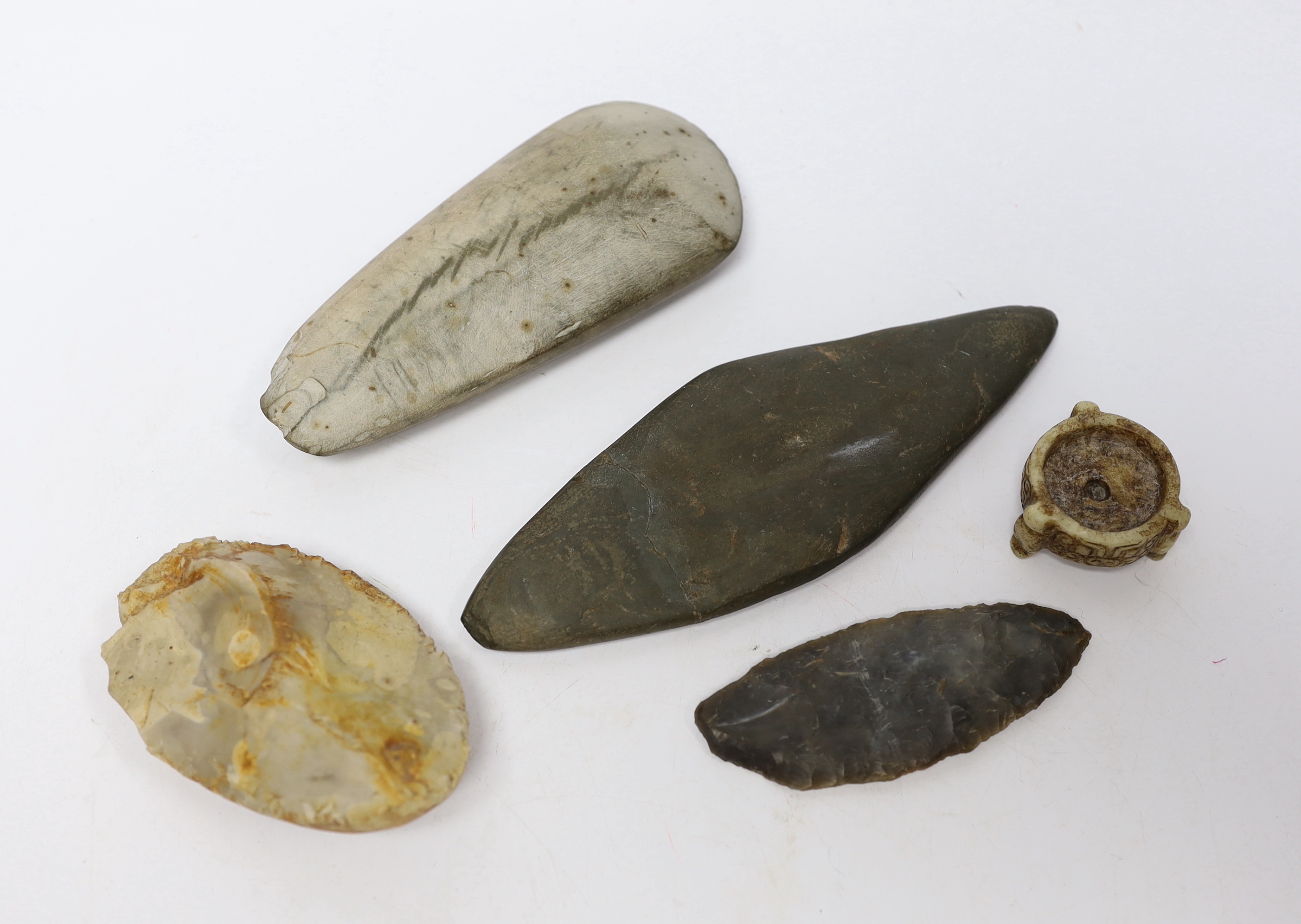 A collection of stone handtools and a Chinese hardstone carving, largest 19cm in length